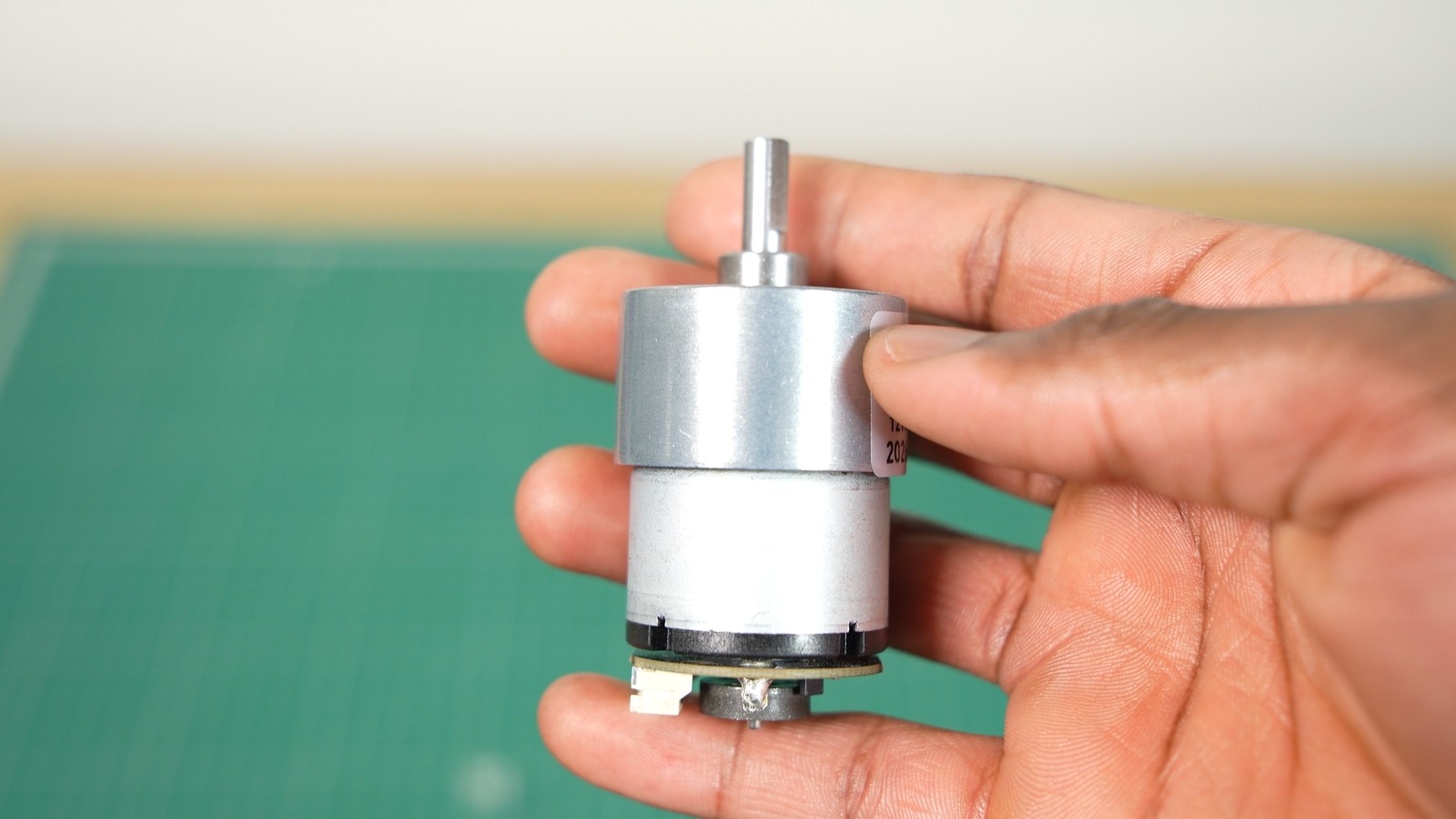The JGB37-520 geared DC motor held in a hand